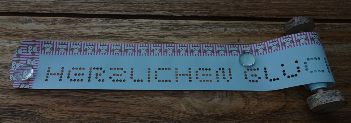 Gru?rollen mit Deko-Band auf blauem Papier mit Holz-Scheiben